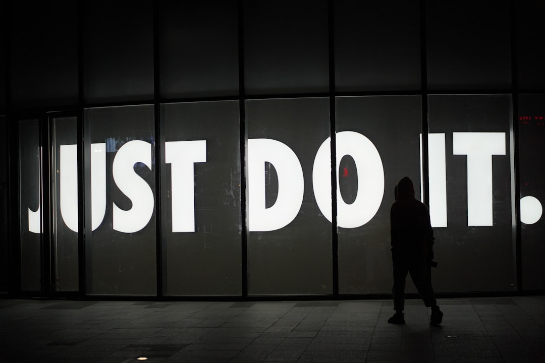 a-person-standing-in-front-of-a-sign-that-says-just-do-it-ytcukuismjk